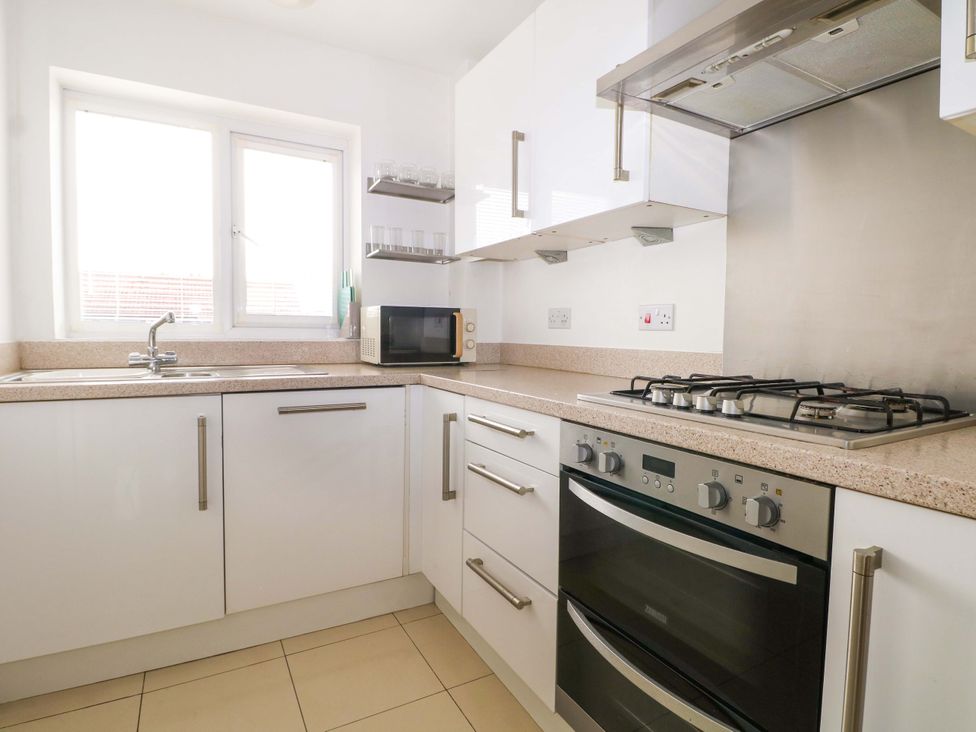 A kitchen with a sink, microwave, gas stove and window at 67a Harbour Way in Shoreham-by-Sea
