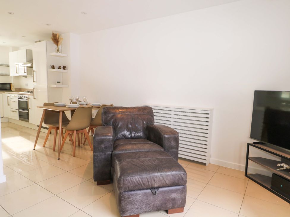 A living room with an armchair and dining area at 67a Harbour Way Shoreham-by-Sea