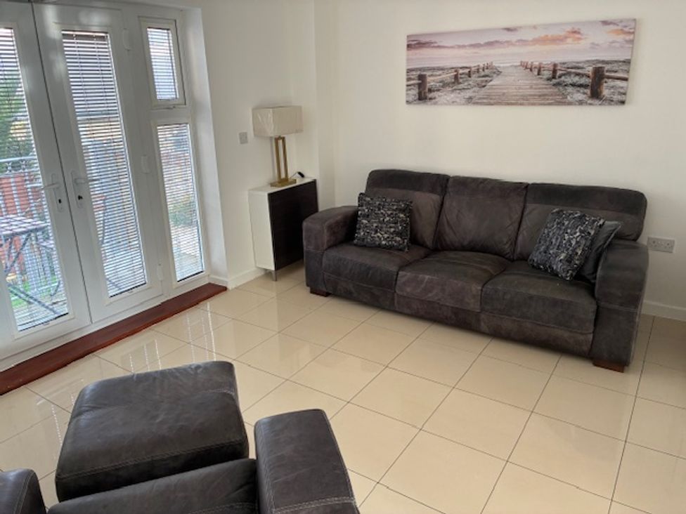 A living room with a sofa and armchair at Harbour Way in Shoreham-By-Sea