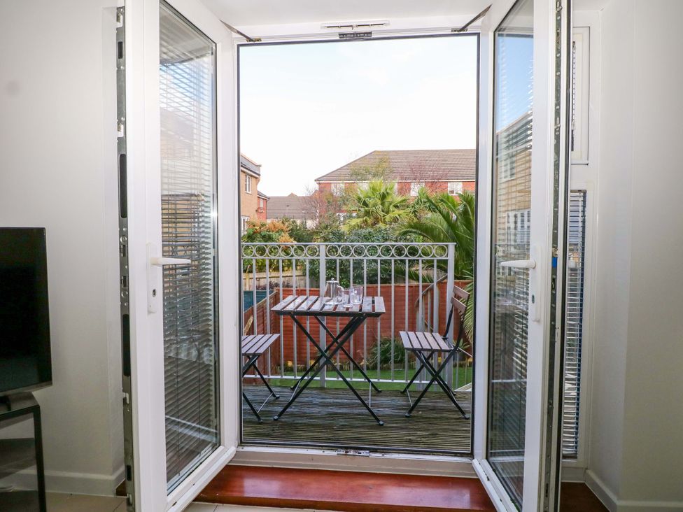 A balcony with a table and chairs overlooking a garden at Harbour Way in Shoreham-By-Sea