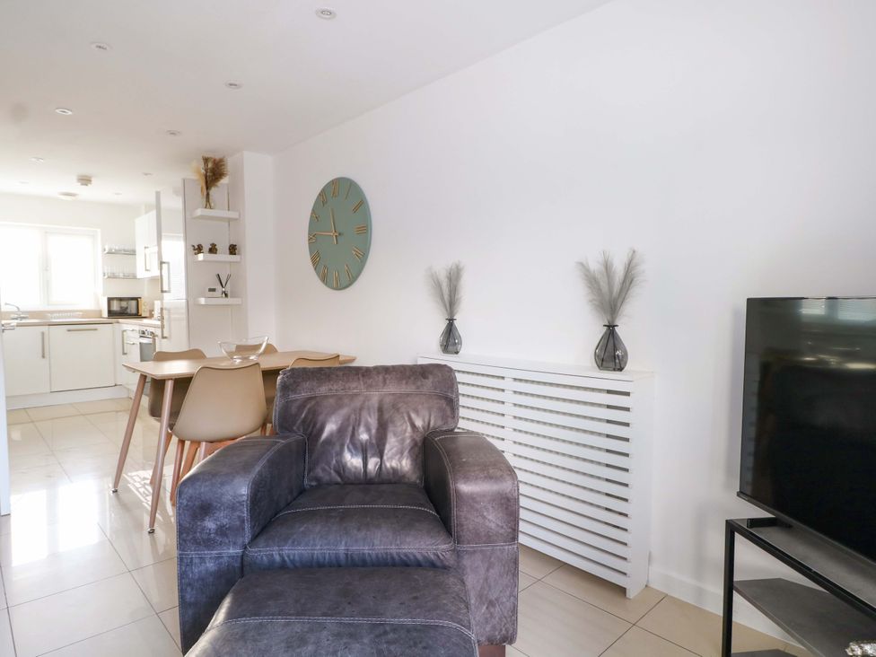 A living room with an armchair, dining area, and television at Harbour Way, Shoreham-By-Sea