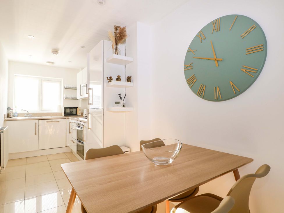 A kitchen with a dining table and wall clock at Harbour Way, Shoreham-By-Sea