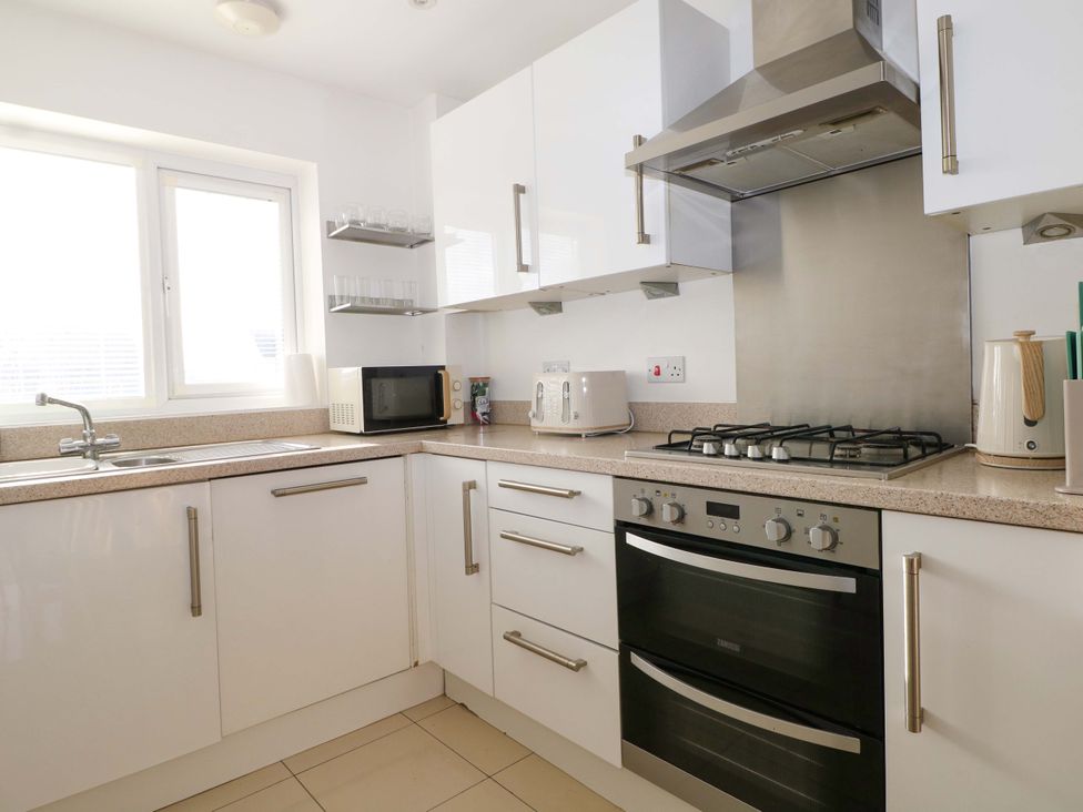A kitchen with a microwave and gas stove at Harbour Way in Shoreham-By-Sea