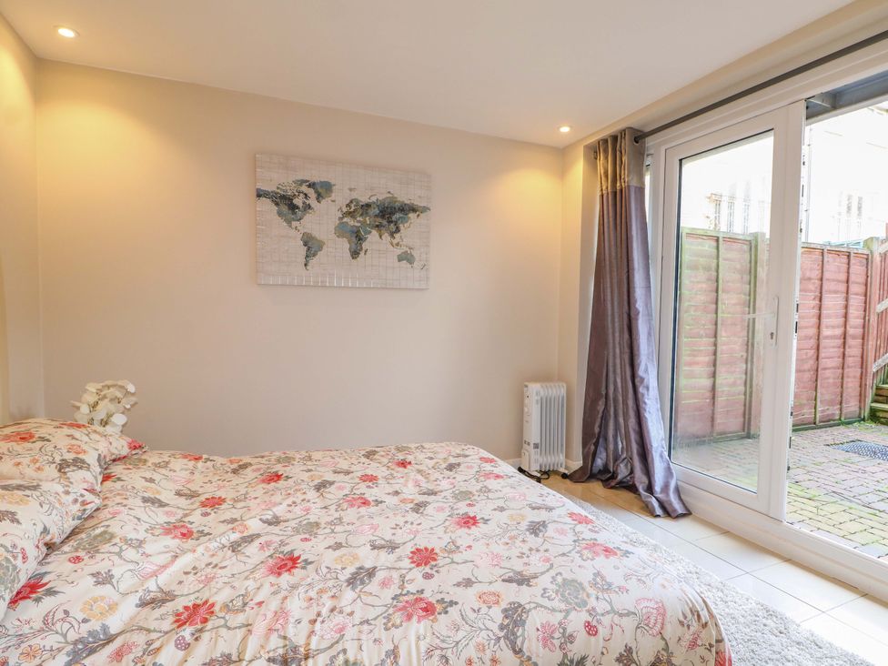 A bedroom with a bed and sliding doors at Harbour Way Shoreham-By-Sea