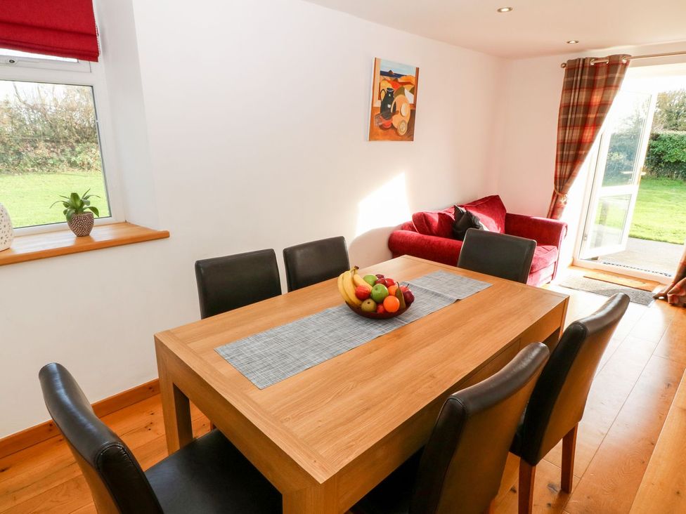 A dining room with a table and chairs at The Old Barn in Pwllheli
