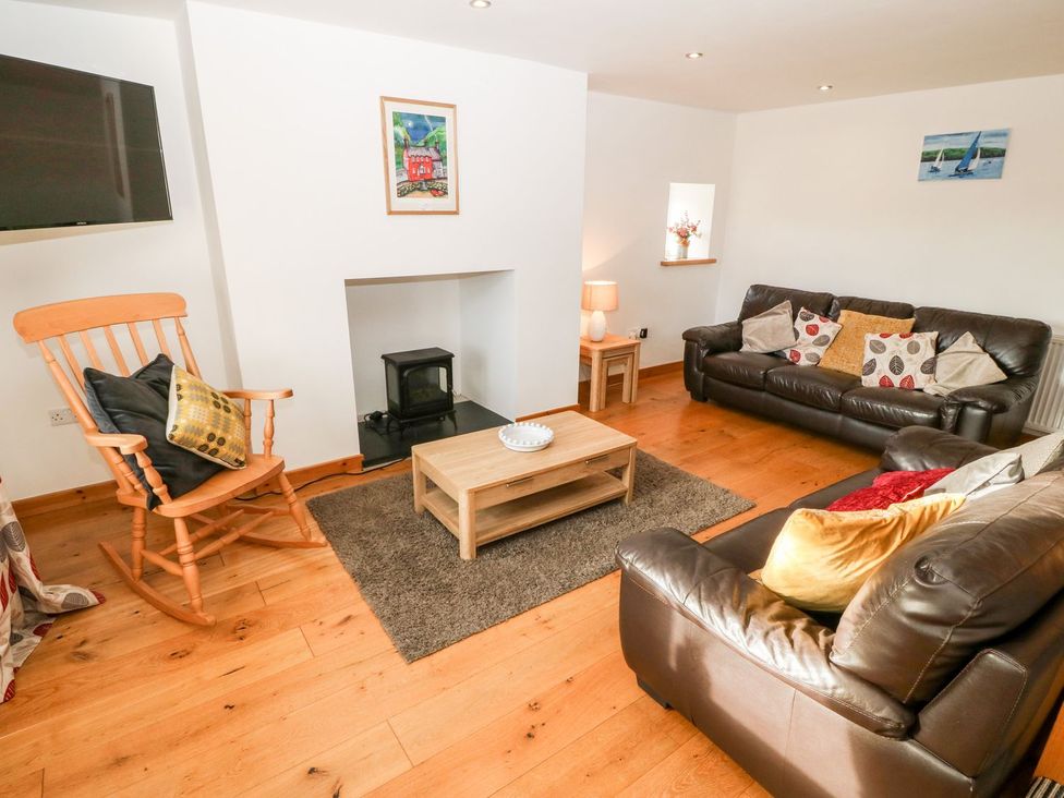 A living room with a sofa and coffee table at The Old Barn in Pwllheli