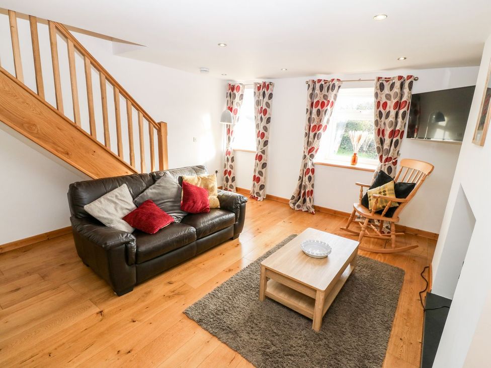 A living room with a sofa and coffee table at The Old Barn in Pwllheli