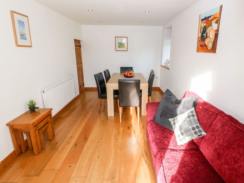 A dining room with a table and chairs at The Old Barn in Pwllheli