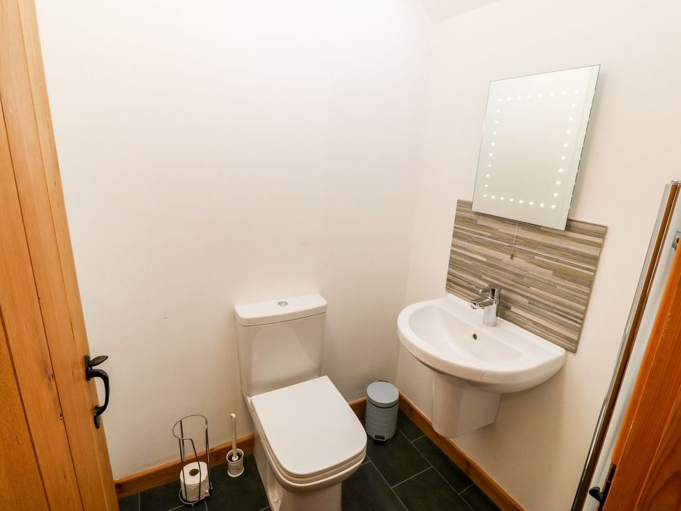 A bathroom with a toilet and sink at The Old Barn in Pwllheli