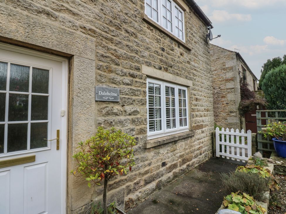 The exterior of a stone cottage with a flower bed at Daleholme in Barnard Castle