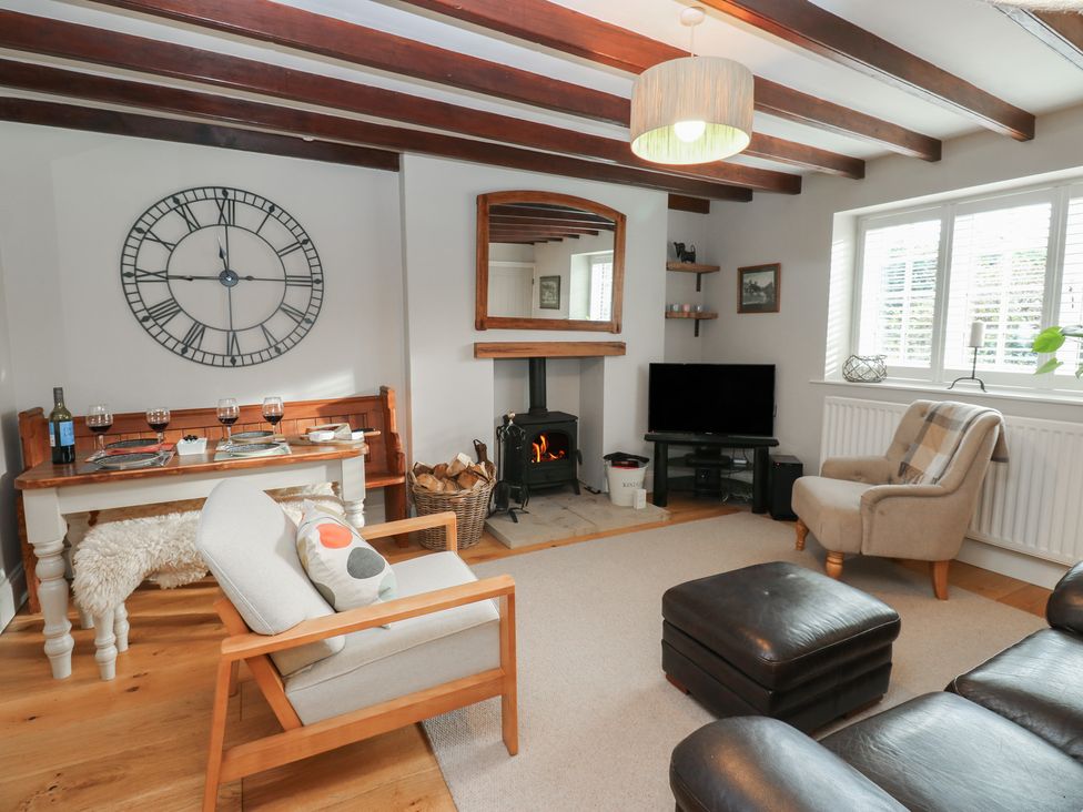 A living room with a clock and a table at Daleholme in Mickleton, Teesdale