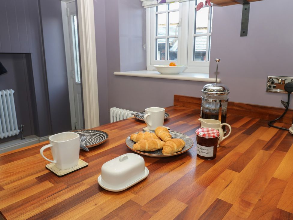A kitchen with a table containing a cup, plate, croissants, butter dish, and jam jar at Daleholme, Mickleton, Teesdale