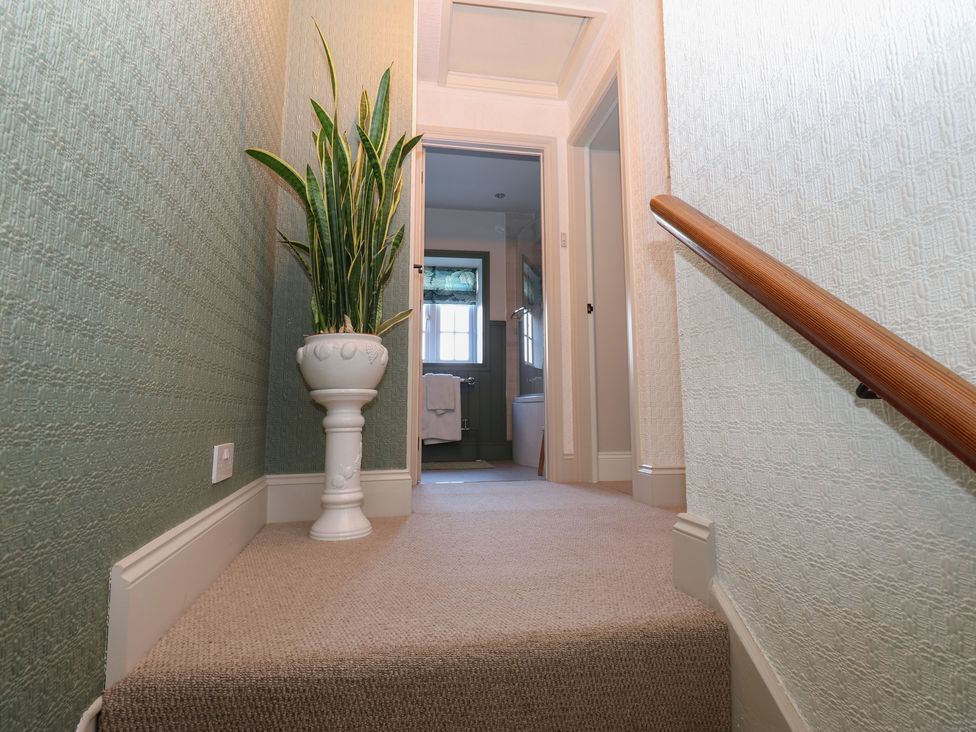 A staircase with a potted plant and doorway at Daleholme Mickleton, Teesdale