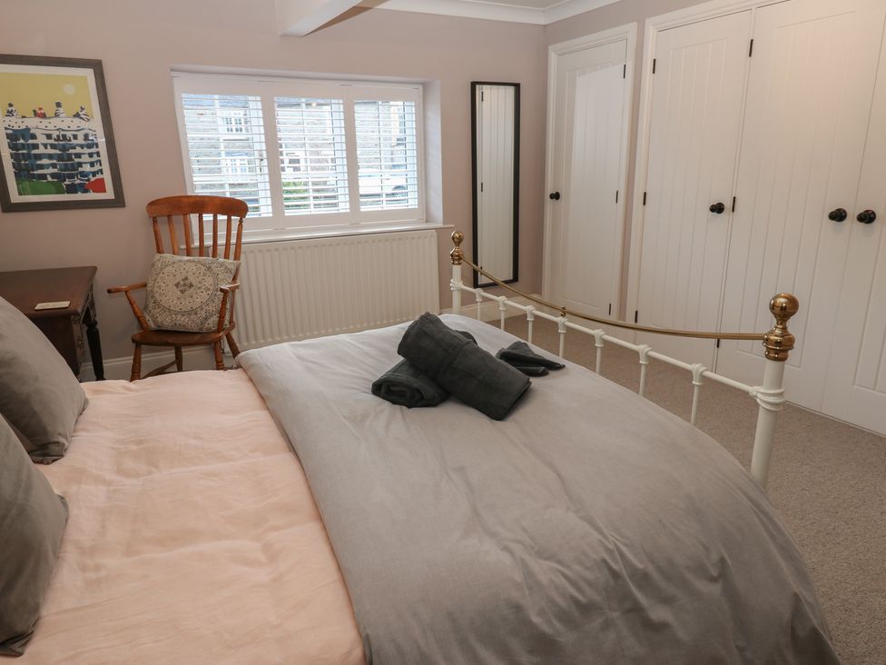 A bedroom with a bed, chair, and wardrobe at Daleholme in Mickleton, Teesdale