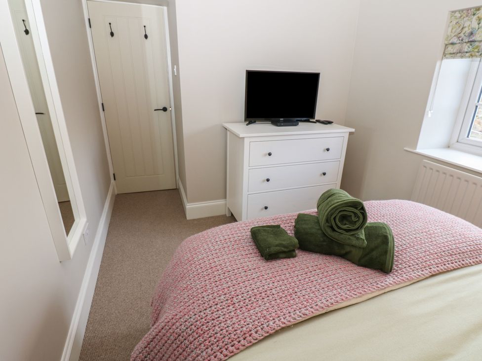 A bedroom with a bed and television at Daleholme in Mickleton, Teesdale