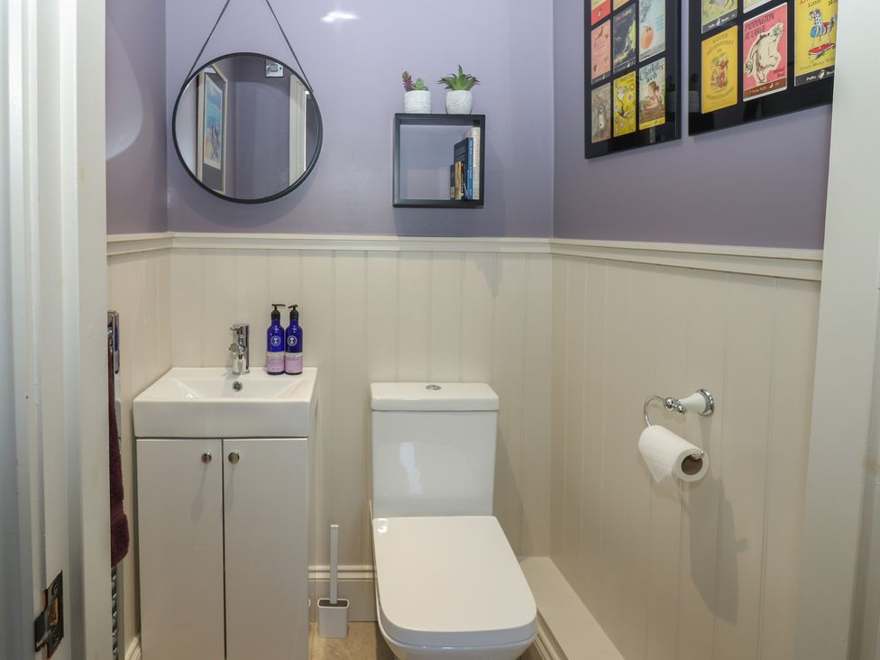 A bathroom with sink, toilet, and mirror at Daleholme in Mickleton, Teesdale