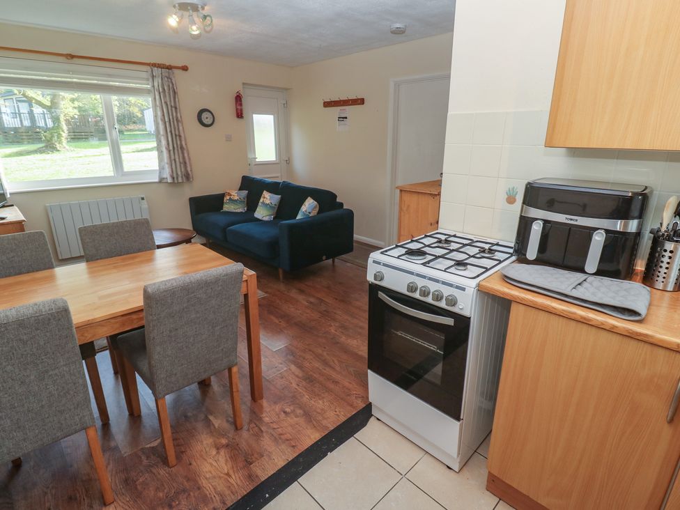 A kitchen and dining area with table, chairs, and a stove at Little Egret - Number 2