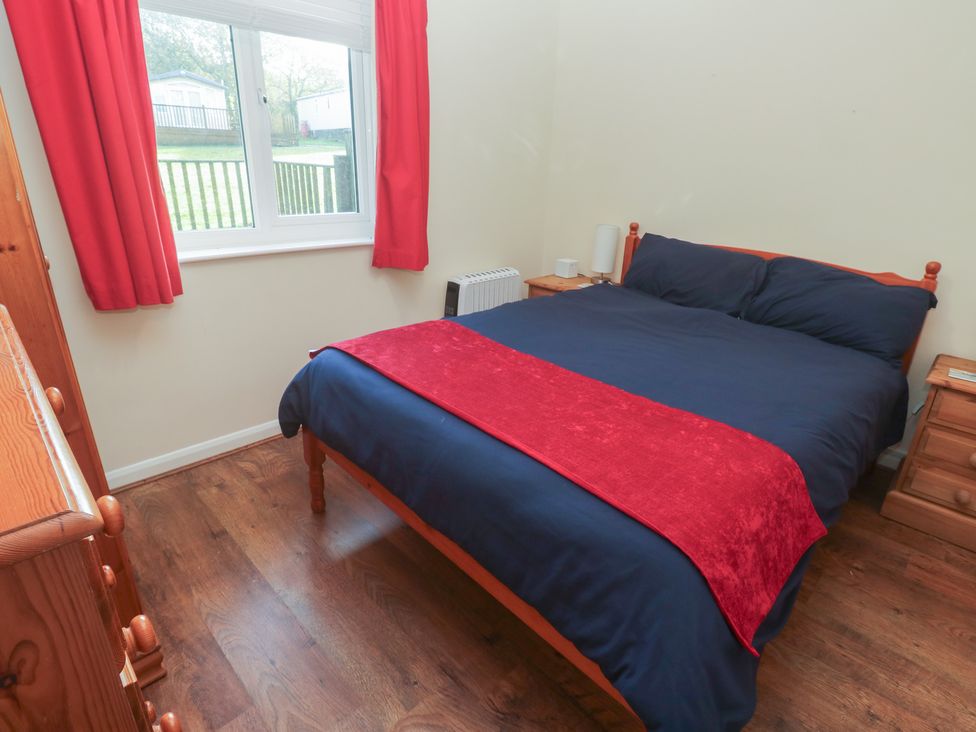 A bedroom with a bed and dresser at Little Egret - Number 2