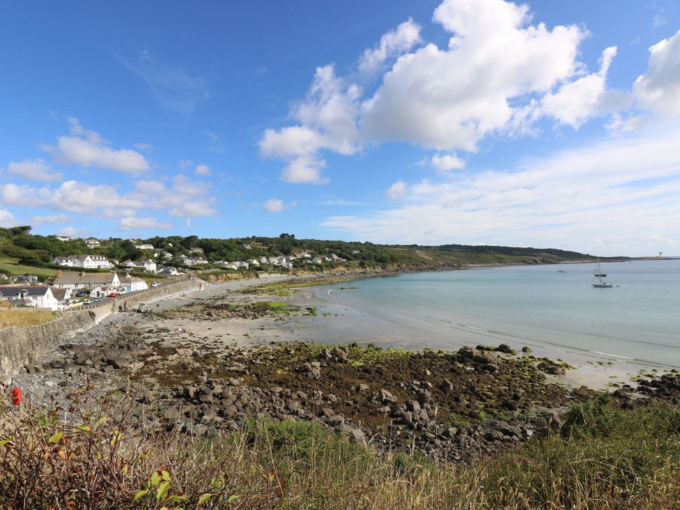 A beach with water, rocks, and boats at Little Egret - Number 2