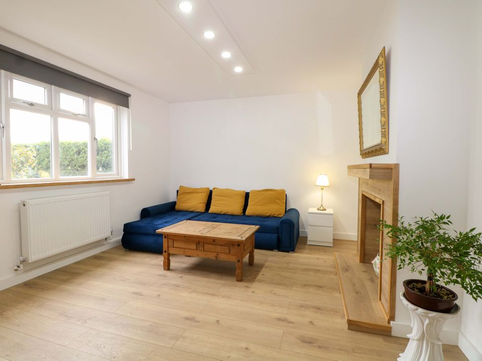 A living room with a blue sofa and a coffee table at 7 Oaks Track in Carshalton