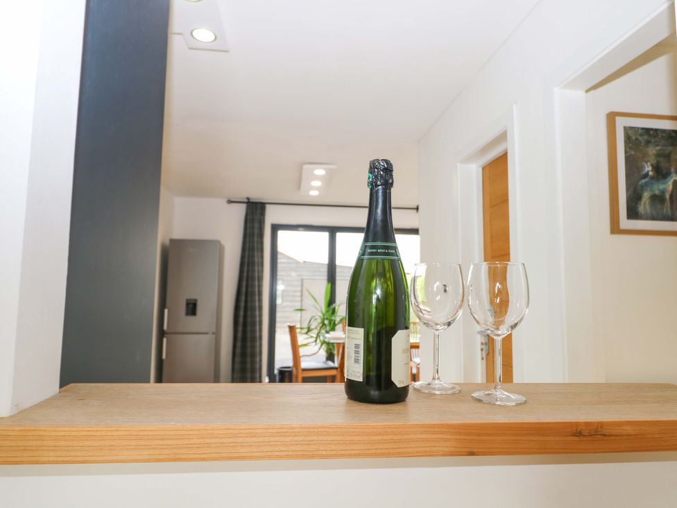 A bottle of champagne and two glasses in a kitchen at 7 Oaks Track Carshalton