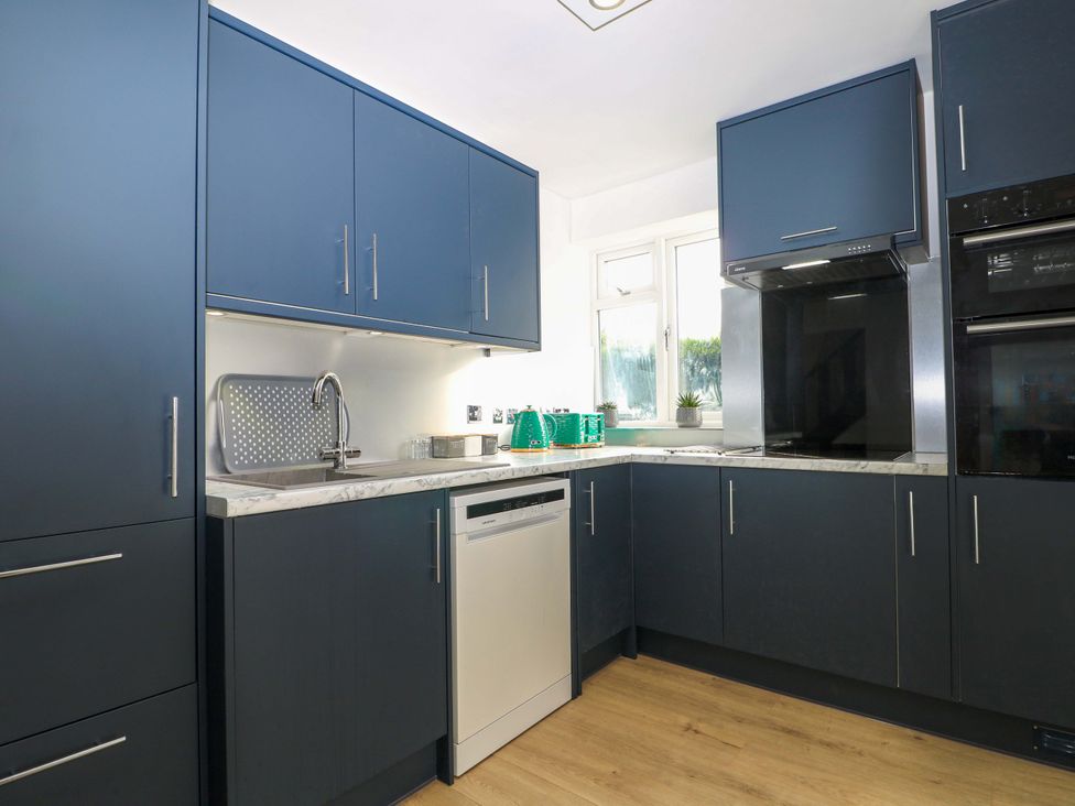 A kitchen with a sink and dishwasher at 7 Oaks Track in Carshalton