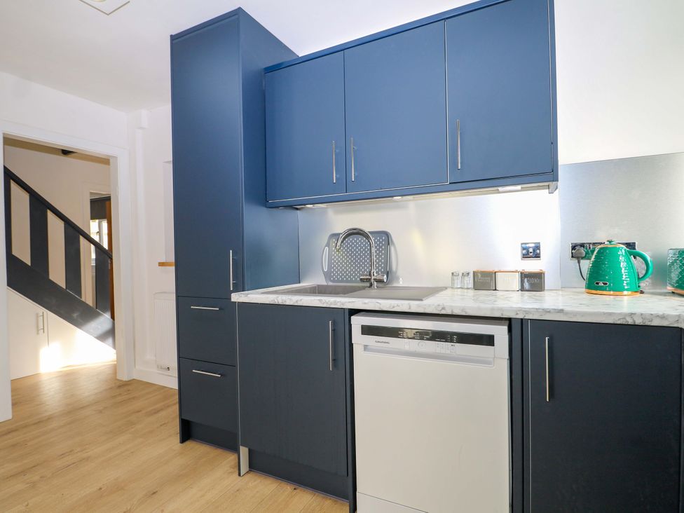 A kitchen with cabinets, a sink, and a dishwasher at 7 Oaks Track in Carshalton