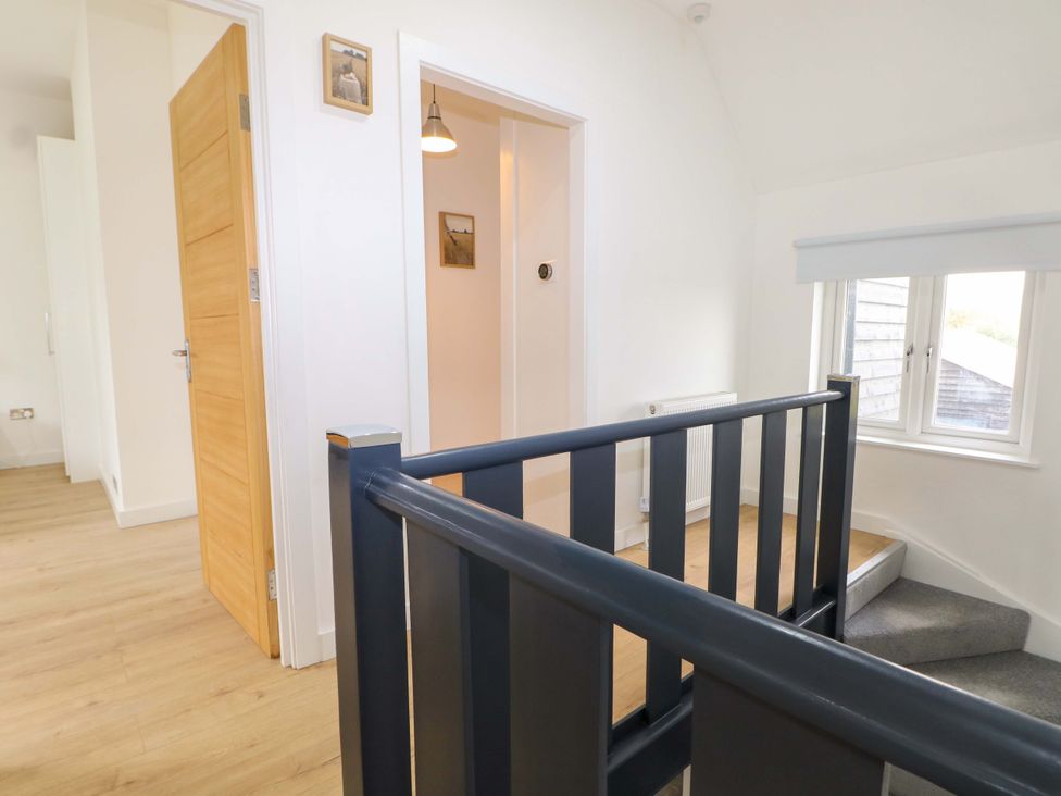A hallway with stairs and doors at 7 Oaks Track in Carshalton