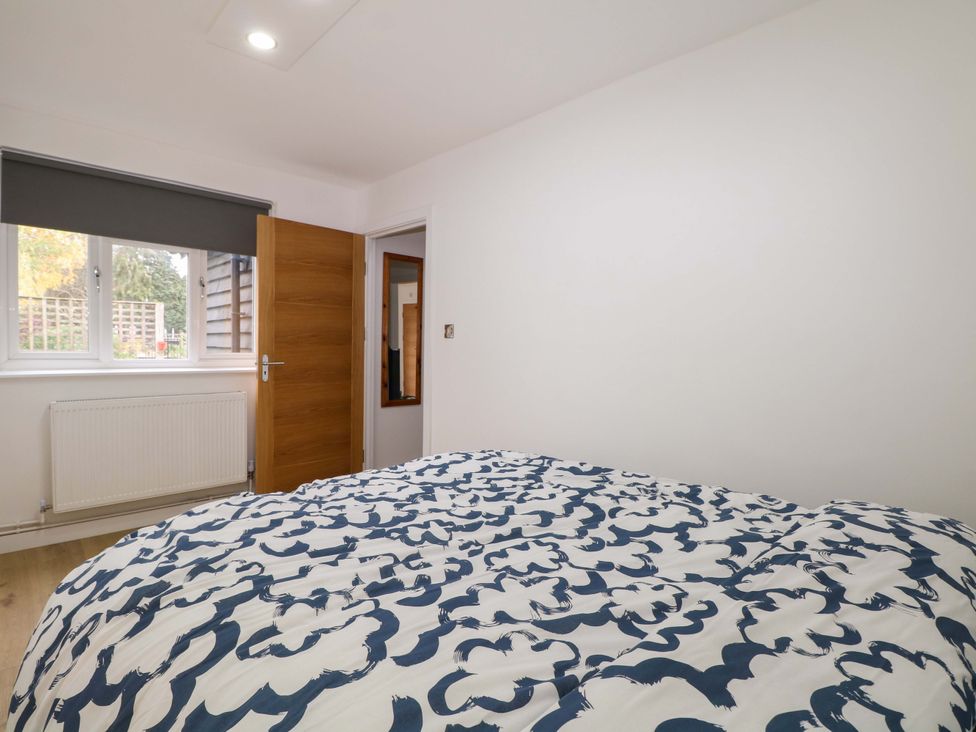 A bedroom with a bed and window at 7 Oaks Track in Carshalton
