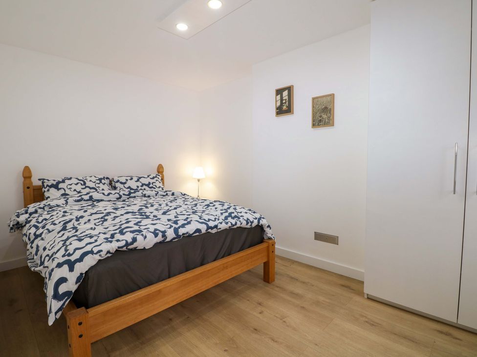 A bedroom with a bed and lamp at 7 Oaks Track in Carshalton