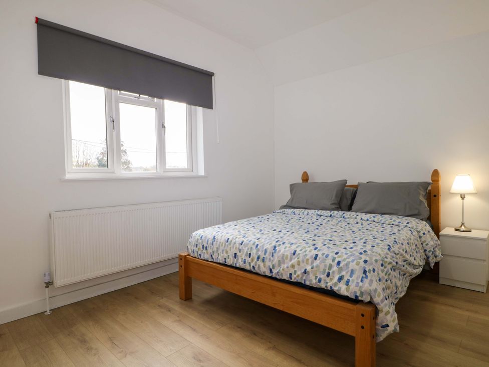 A bedroom with a bed and window at 7 Oaks Track in Carshalton