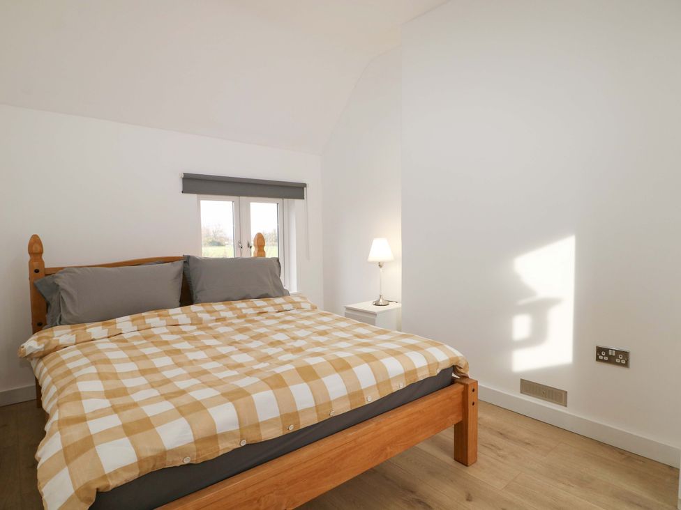 A bedroom with a bed and bedside lamp at 7 Oaks Track in Carshalton