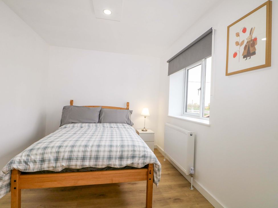 A bedroom with a bed and lamp at 7 Oaks Track in Carshalton