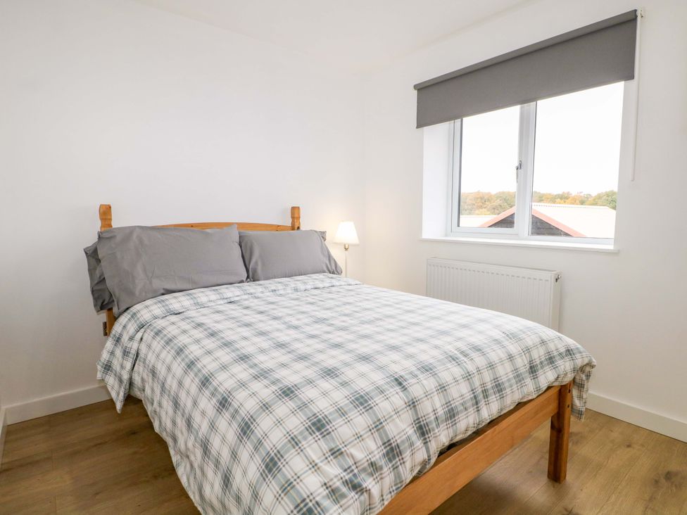 A bedroom with a bed and lamp at 7 Oaks Track in Carshalton