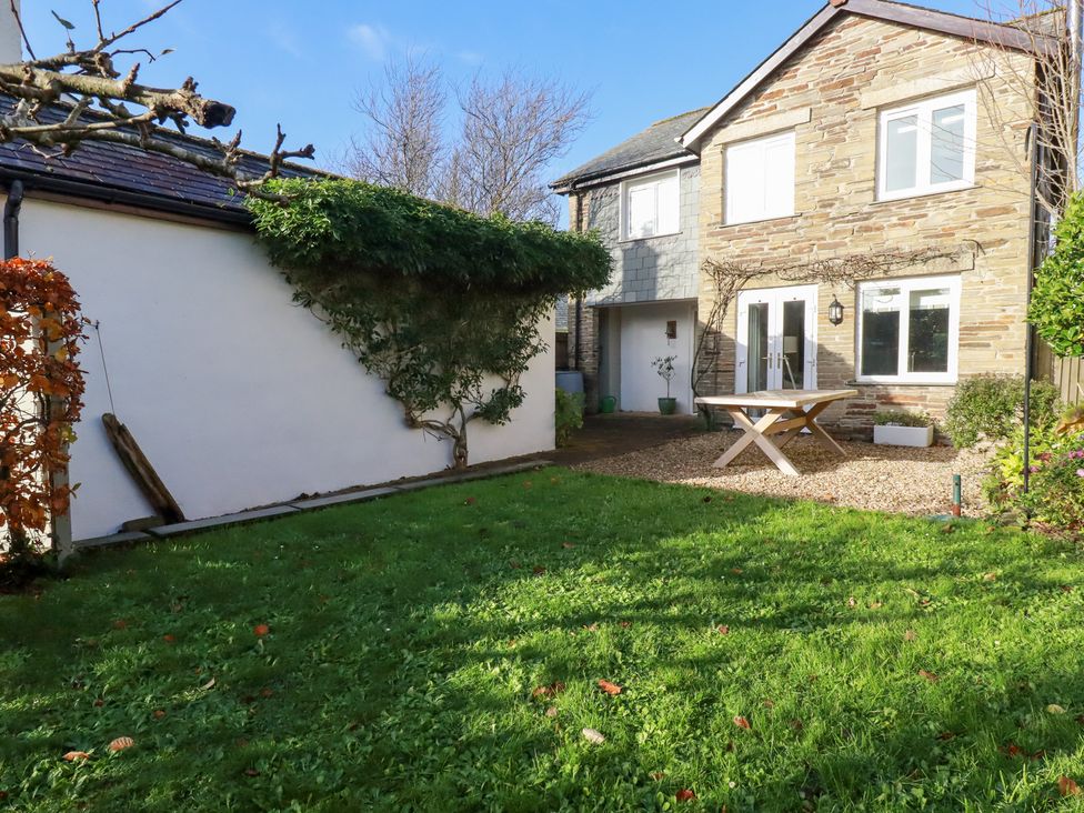 A garden with a table and chairs near a house at The Mizzen in St Endellion near Port Isaac
