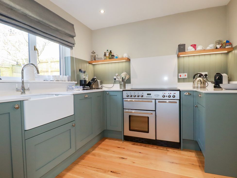 A kitchen with cabinets, oven, sink and appliances at The Mizzen in St Endellion near Port Isaac