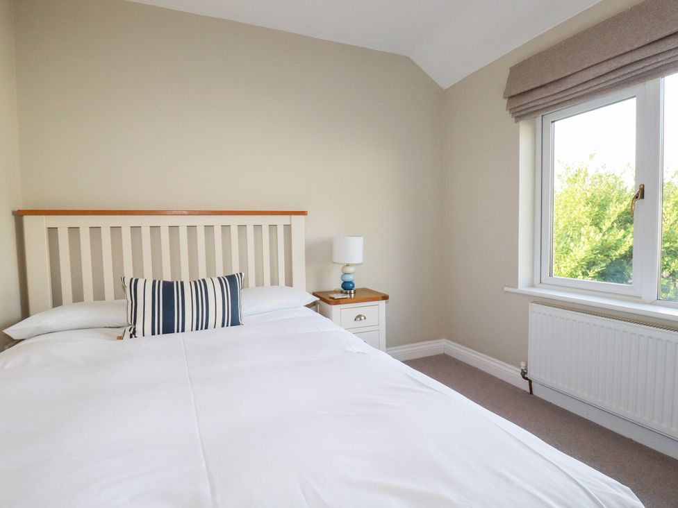 A bedroom with a bed and nightstand at The Mizzen St Endellion near Port Isaac