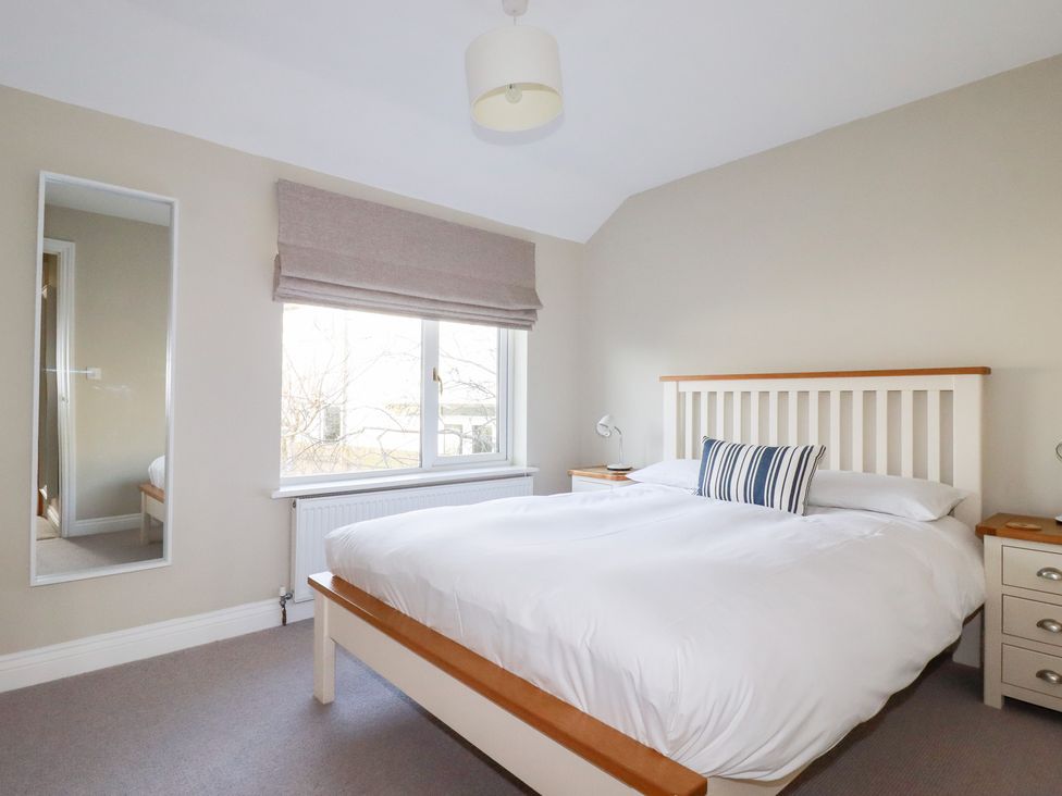 A bedroom with a bed and bedside table at The Mizzen St Endellion near Port Isaac