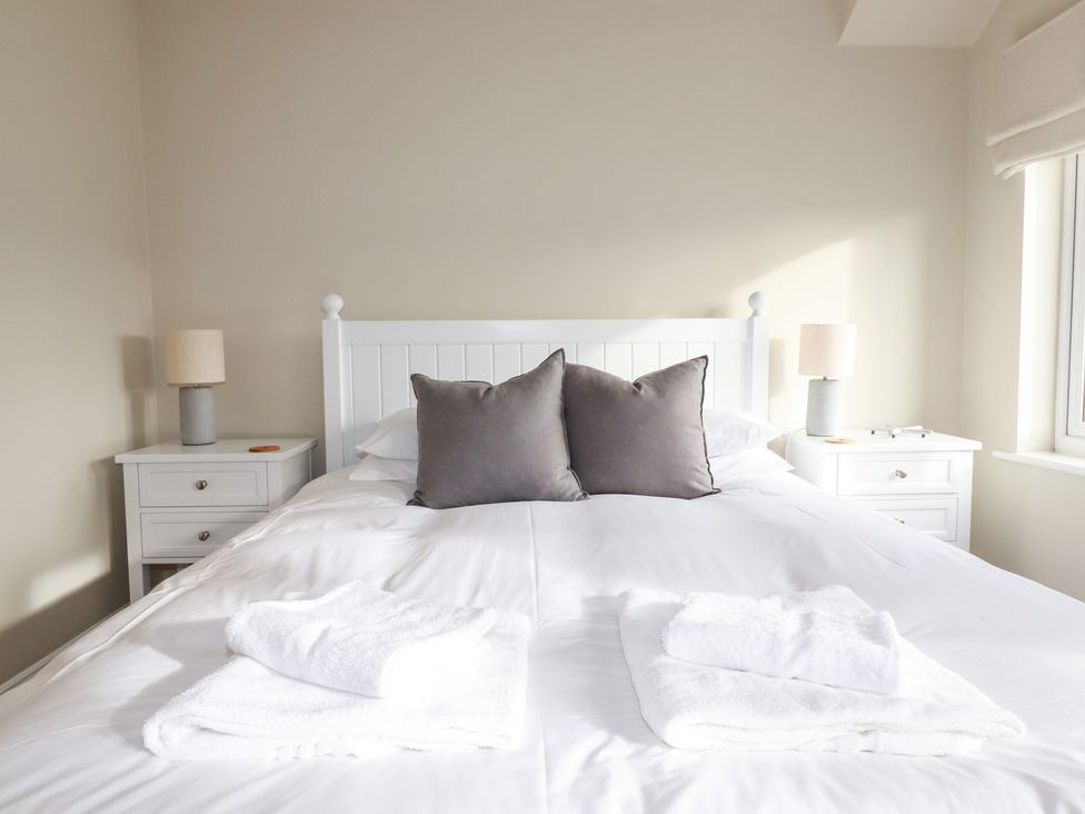 A bedroom with a bed and bedside tables at The Mizzen in St Endellion near Port Isaac