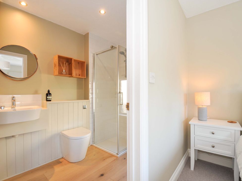 A bathroom with a sink, toilet, and shower at The Mizzen St Endellion near Port Isaac