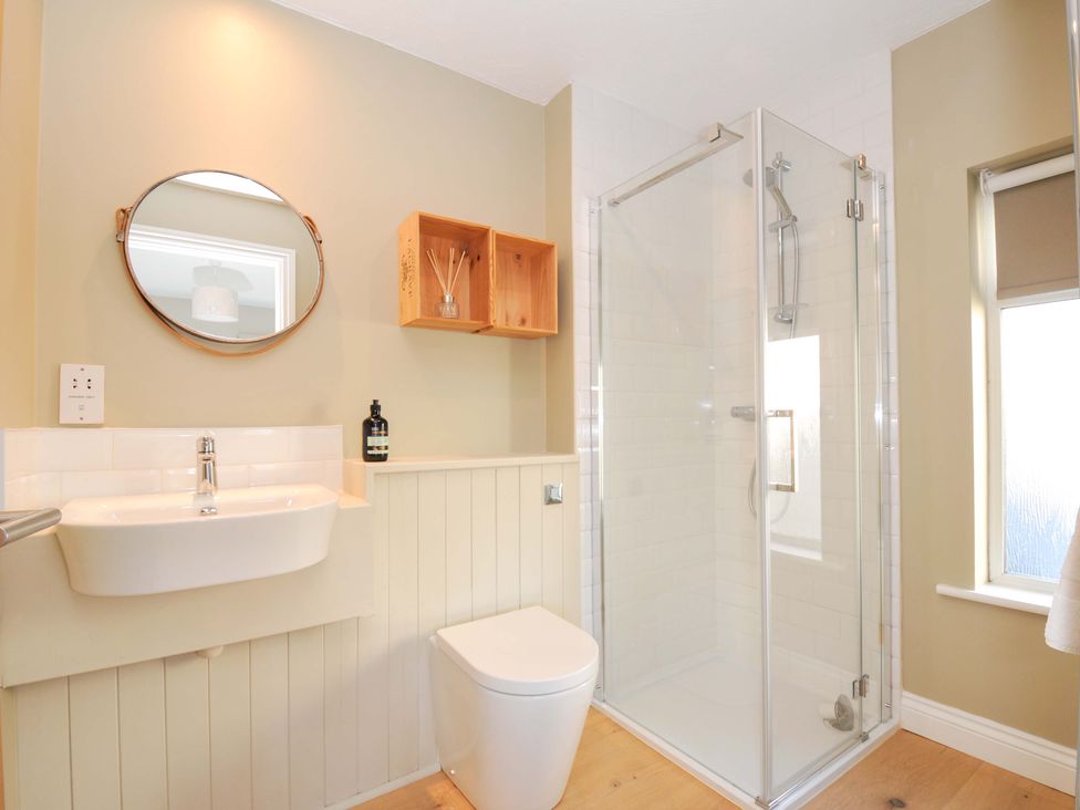 A bathroom with a shower, toilet, and sink at The Mizzen in St Endellion near Port Isaac