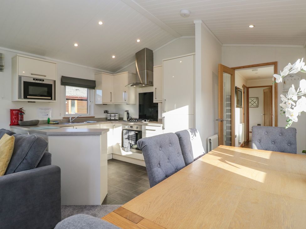 A kitchen with dining table and chairs at Bluebell Lodge in Warton