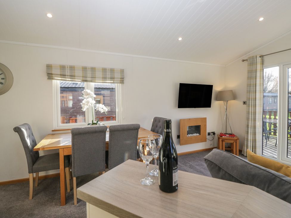 A dining room with a table and chairs at Bluebell Lodge in Warton