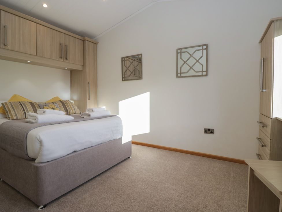 A bedroom with a bed and cabinets at Bluebell Lodge in Warton