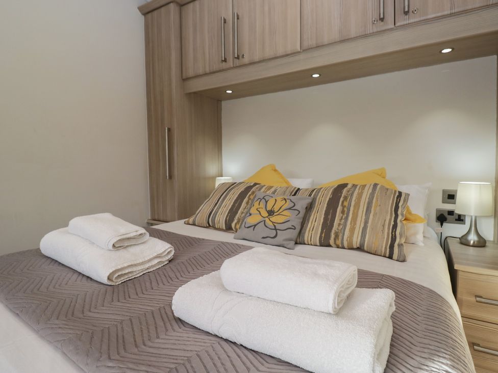 A bedroom with a bed and towels at Bluebell Lodge in Warton