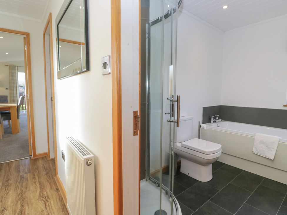 A bathroom with a shower, toilet, and bath at Bluebell Lodge in Warton