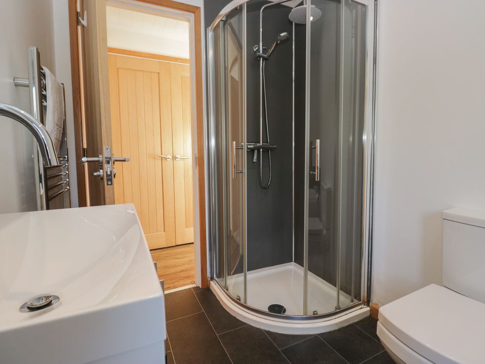 A bathroom with a shower, toilet, and sink at Bluebell Lodge in Warton