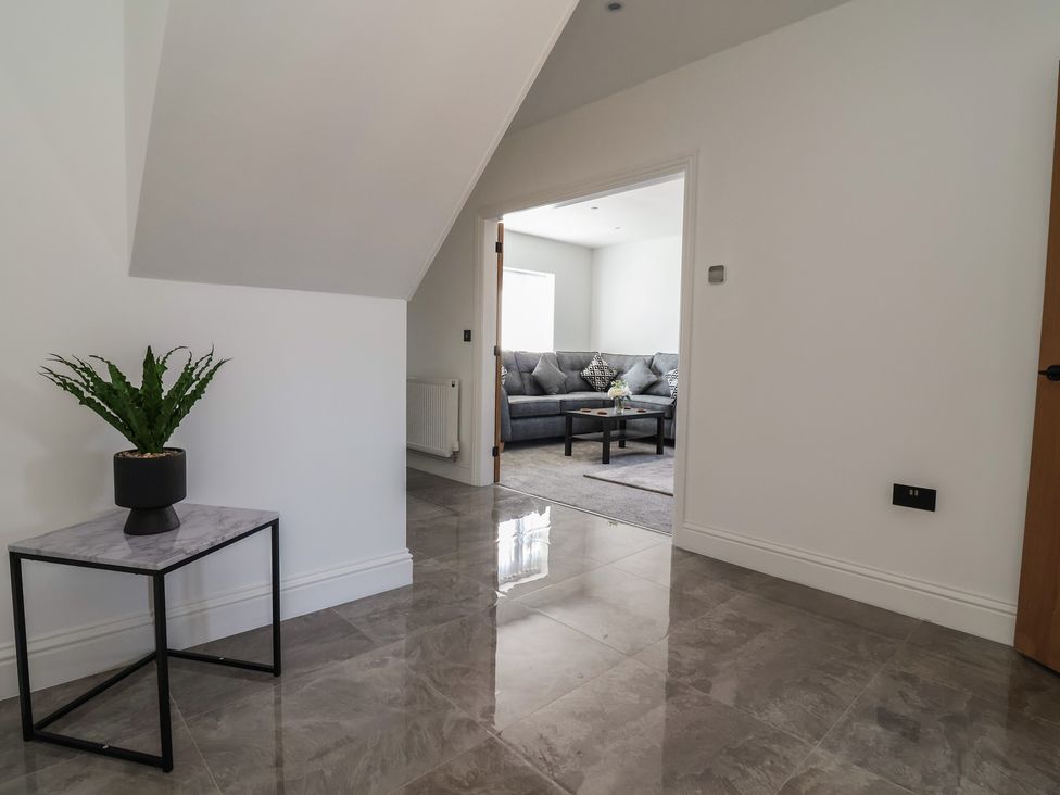 A hallway leading to a living room with a sofa and coffee table at 1 Talbot Drive in Talacre