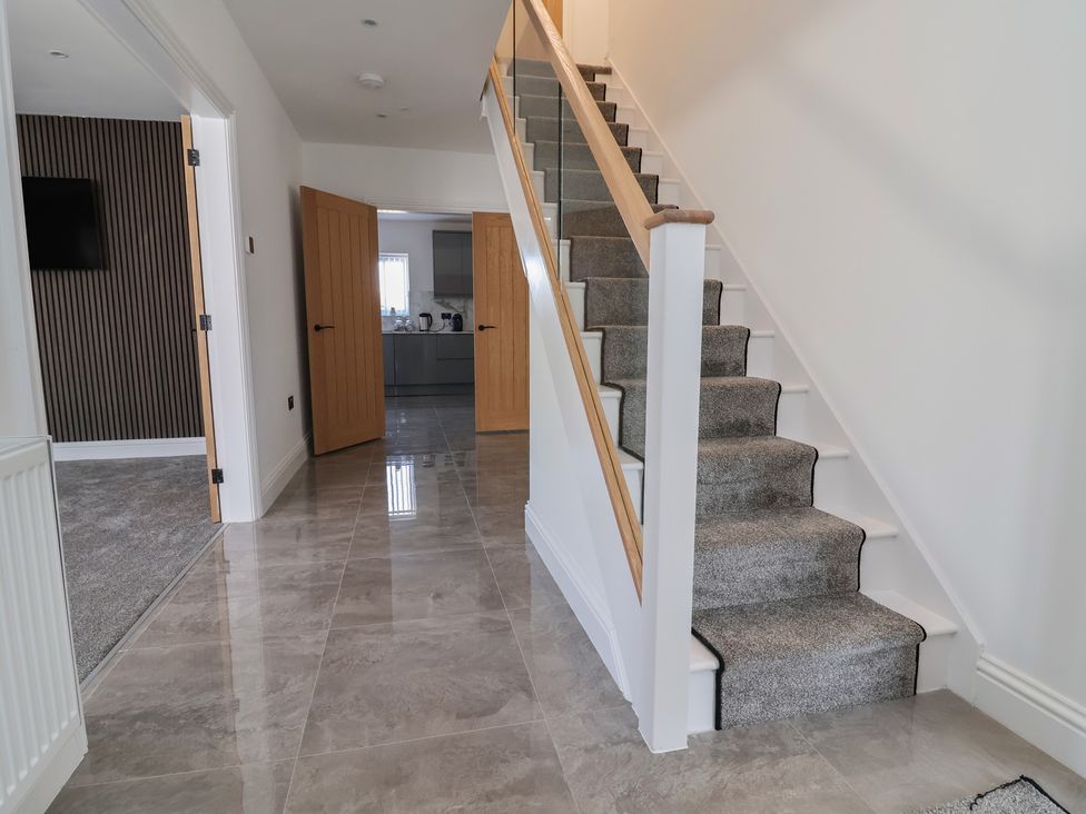 A hallway with stairs and doors at 1 Talbot Drive in Talacre