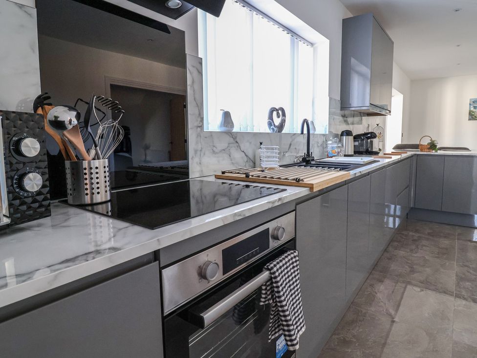 A kitchen with a stove and countertop at 1 Talbot Drive in Talacre
